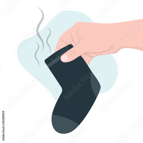 Hand holds dirty blue sock. Household and laundry concept.