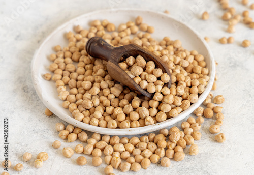 Plate of raw dry chickpea with a scoop