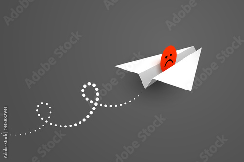 White paper airplane and red unhappy face icon over dark background