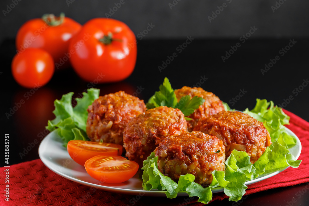 Meat balls in tomato sauce on a black background. Homemade protein meal for healthy diet. Meat balls in tomato sauce on a black background. Homemade protein meal for healthy diet.