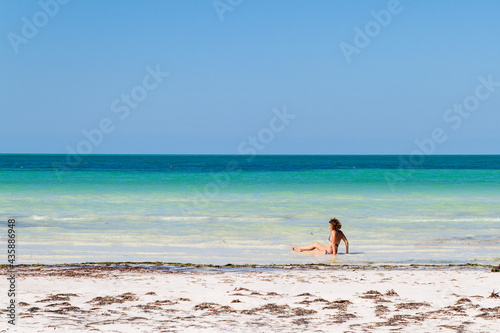 Mujer en la playa de la isla de Holbox, estado de Quintana Roo, pais de Mexico o Mejico en la Rivera Maya o Riviera Maya en la peninsual de Yucatan