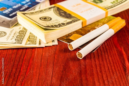 Cigarettes and payment cards on a several dollar on the table. Close up view