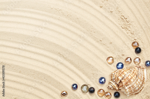 seashells with glass stones on the sand in summer