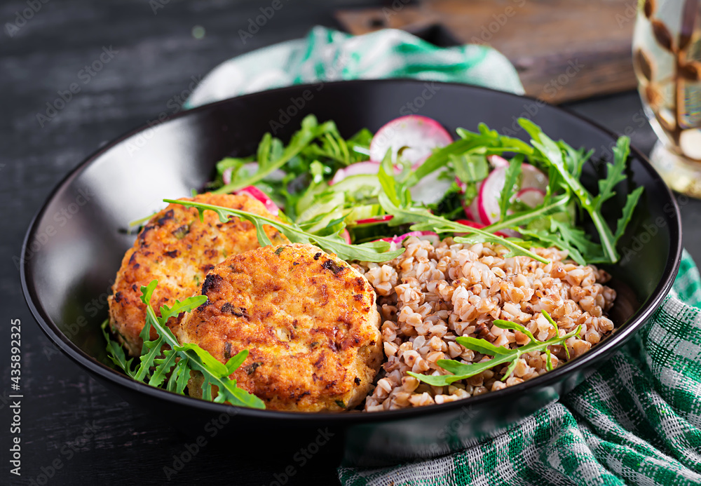 Healthy dinner. Lunch bowl with buckwheat porridge, fried chicken cutlets and fresh vegetable salad of arugula, cucumber and radish. Healthy dinner. Lunch bowl with buckwheat porridge, fried chicken cutlets and fresh vegetable salad of arugula, cucumber and radish.
