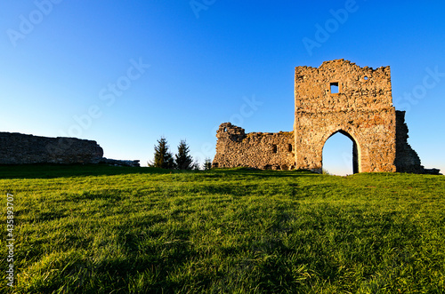 Wide-angle landscape view of the ruins of main gate and defensive wall of Krements castle. Blue sky in the background. Mountain Bone in Kremenets, Ternopil province, Ukraine