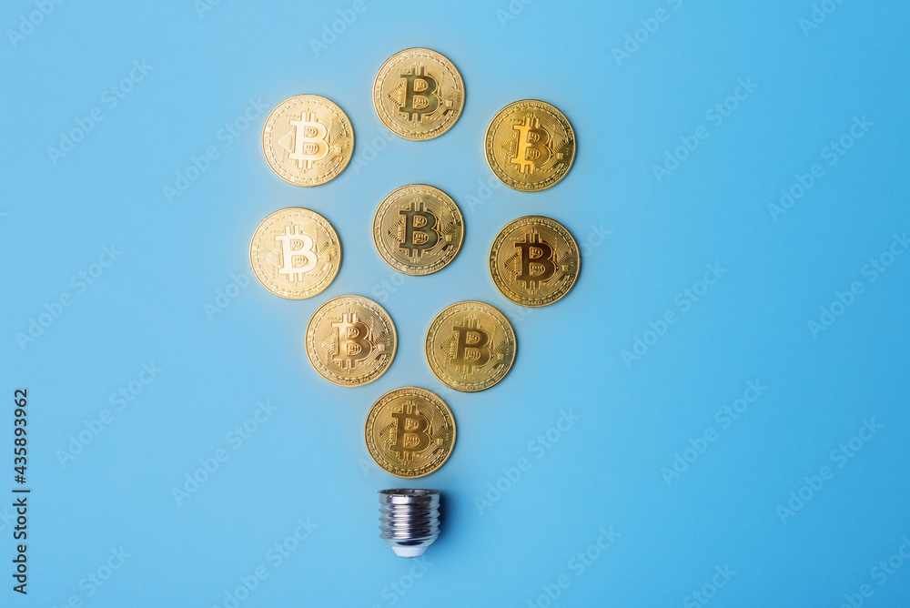 Golden bitcoins arranged in a shape of light bulb on blue background. Cryptocurrency and virtual money concept Golden bitcoins arranged in a shape of light bulb on blue background. Cryptocurrency and virtual money concept