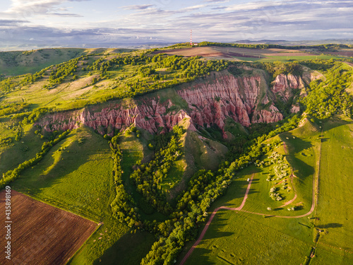 Aerial photography of the Red Ravine located in Romania, Alba county. Photo taken from a drone at sunset in spring season. Drone shot of a canyon formation from a high angle
