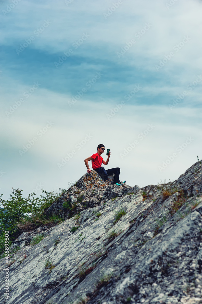 A young man is sitting on the rocks in Sićevo (Sicevo, Sicevo gorge)