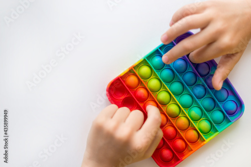 colorful antistress sensory toy fidget push pop it in kid's hands. Copy space