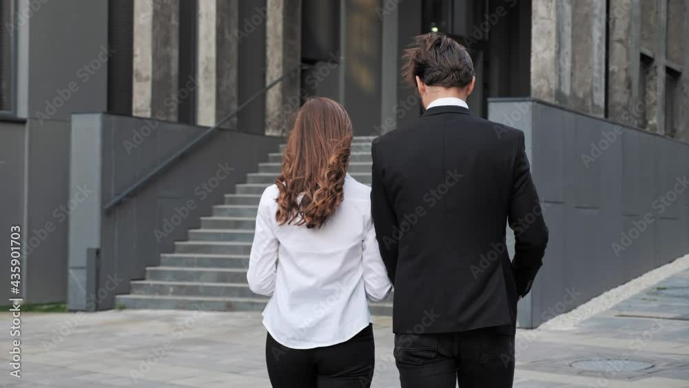Back view of businesspeople having conversation while are going to work.
