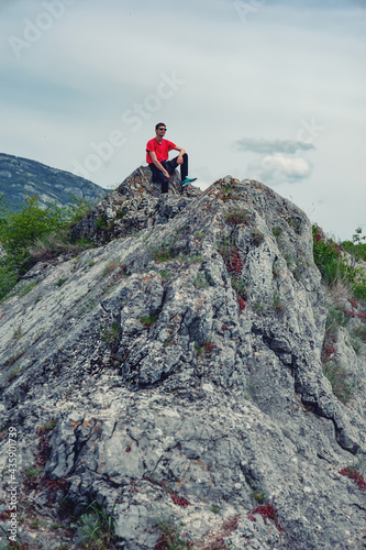 A young man is sitting on the rocks in Sićevo (Sicevo, Sicevo gorge)