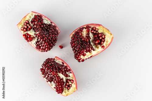 split pieces of pomegranate on a white background