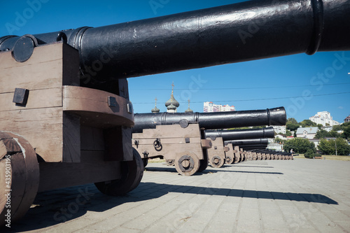Replica cannons from battleship Goto Pristancia on Admiralteyskaya Square on clear sunny day. Behind cannons located Assumption Admiralty temple. photo