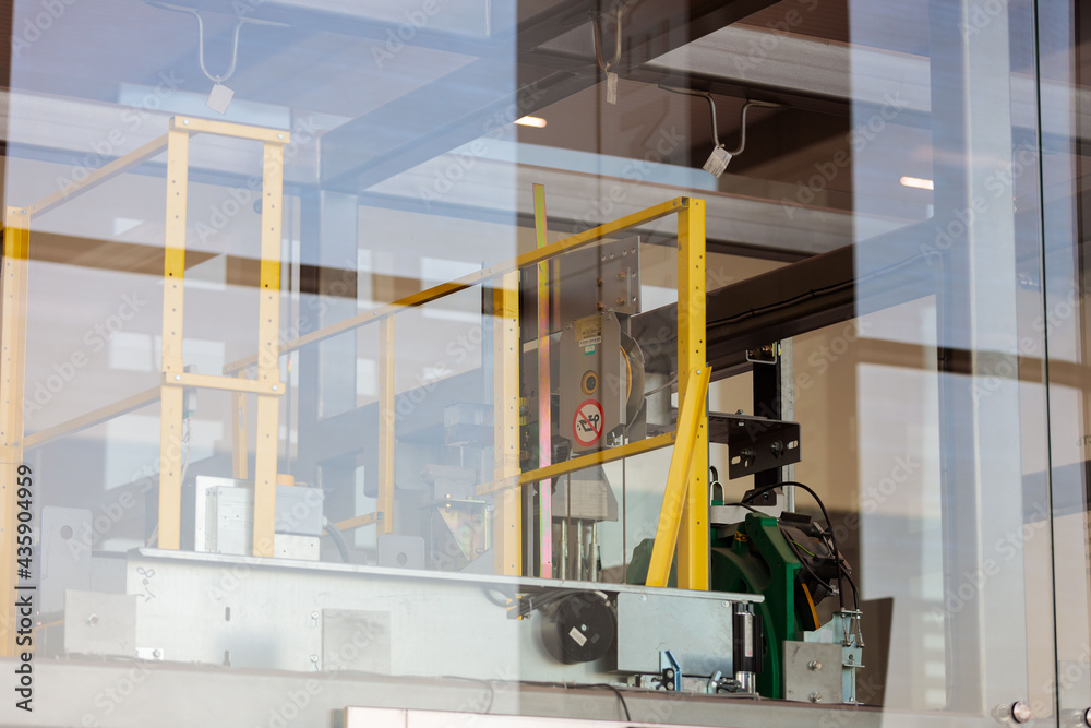 Mechanisms and details of the glass elevator at the airport. View through glass.