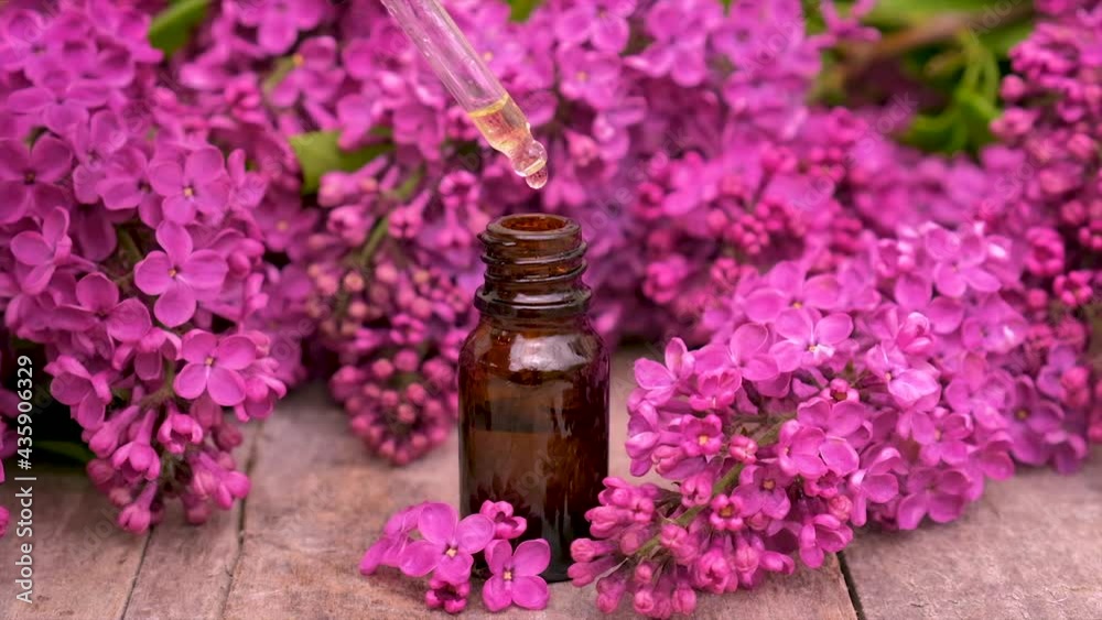 Lilac essential oil and extract in a small bottle. Selective focus. Lilac essential oil and extract in a small bottle. Selective focus.