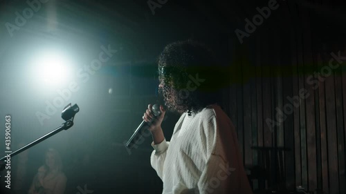CU HANDHELD Black African American young female comedian finishing her stand-up monologue and leaving stage of a small venue. Shot with ARRI Alexa Mini LF with 2x anamorphic lens