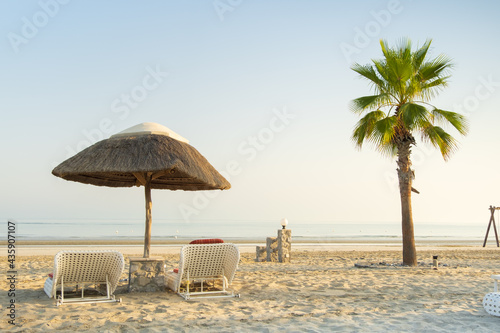 Fototapeta Naklejka Na Ścianę i Meble -  morning light on the beach with beach ubrella and palm tree