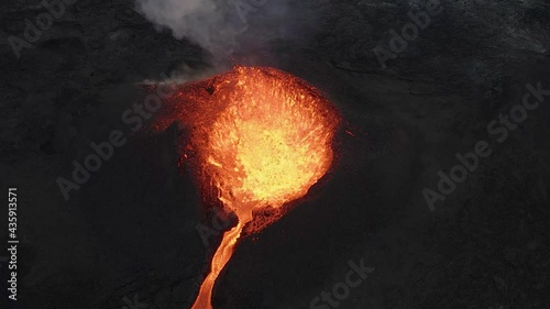 Drone view ascending over fountain of magma erupting from volcano crater, Iceland. Slow motion photo