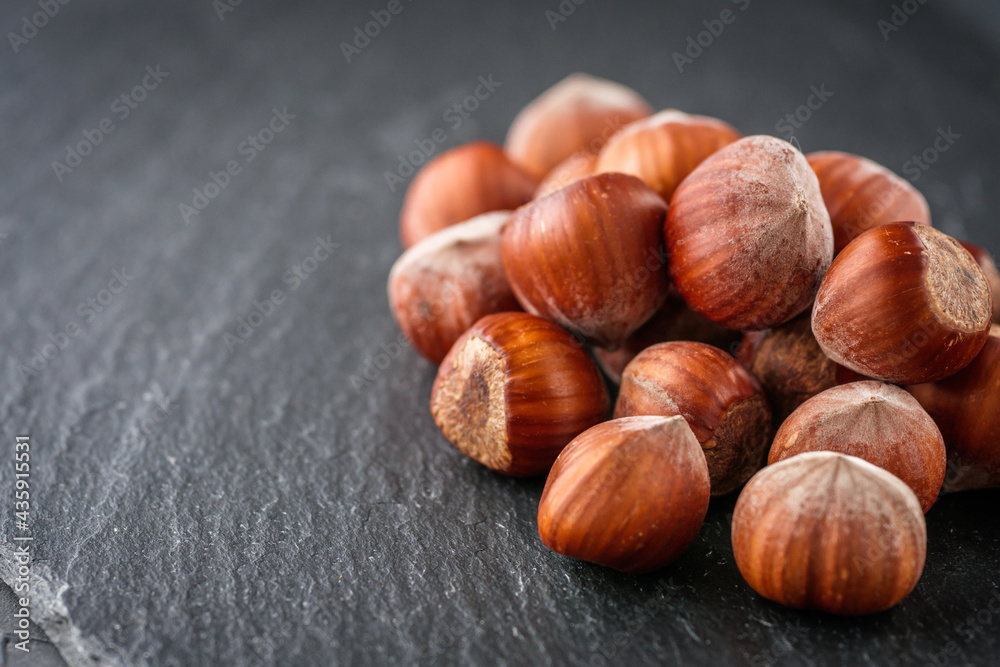fresh natural hazelnuts on a dark stone background fresh natural hazelnuts on a dark stone background