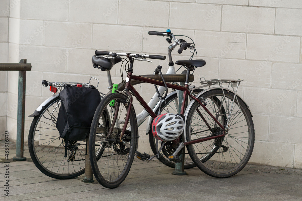 A Photograph of Two Cycles Parked On a Bicycle Parking Rack In a Urban Scene in City Centre