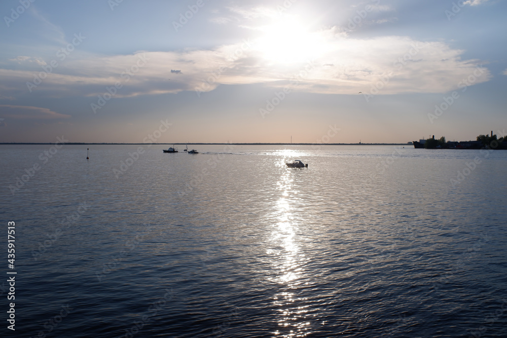 the setting evening sun against the backdrop of a large wide river the setting evening sun against the backdrop of a large wide river