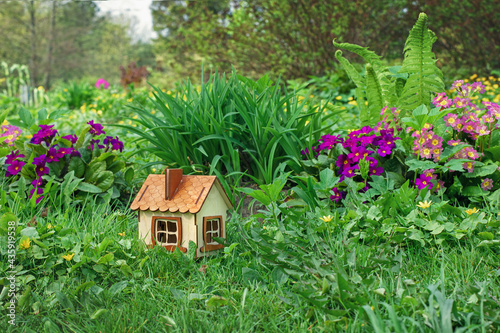 miniature wooden house on green grass like symbol of eco friendly buiding, long term investment and heathy lifestyle © Leka