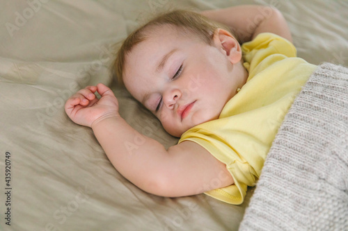 Baby one-year-old sleeping in the bedroom on the bed