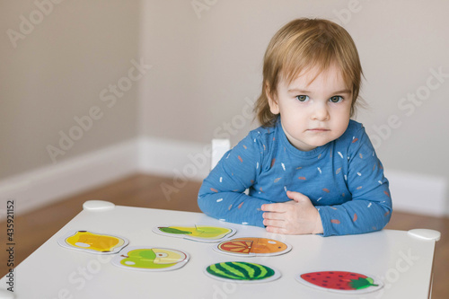 One and a half year old girl collects puzzles. Psychomotor skills and the development of logical thinking photo