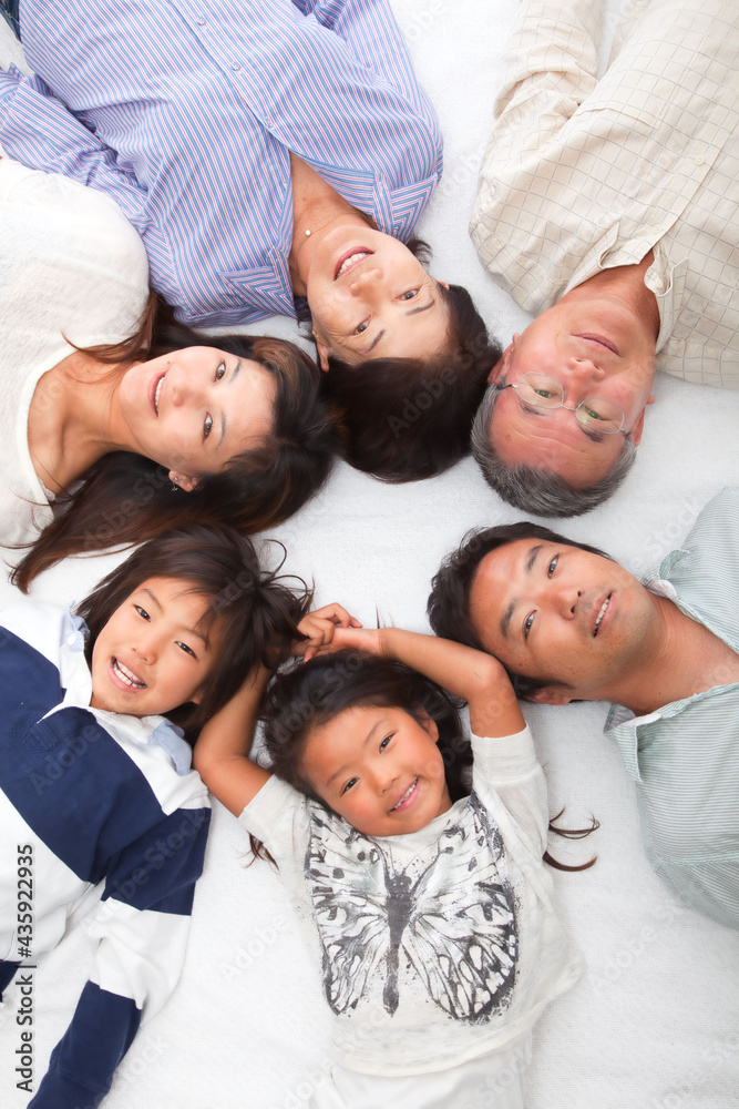 Japanese 3rd generation family lying down and looking at the camera
