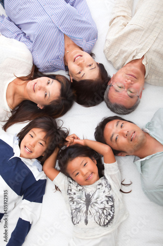 Japanese 3rd generation family lying down and looking at the camera