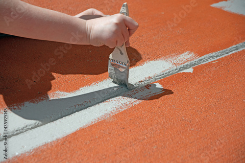 A child is holding a paint brush and painting photo