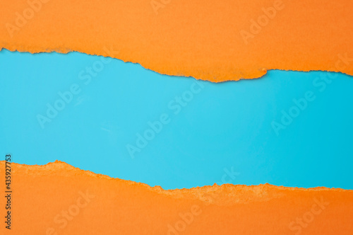 Horizontal border and colorful backgrounds concept with torn orange paper and copy space on blue background