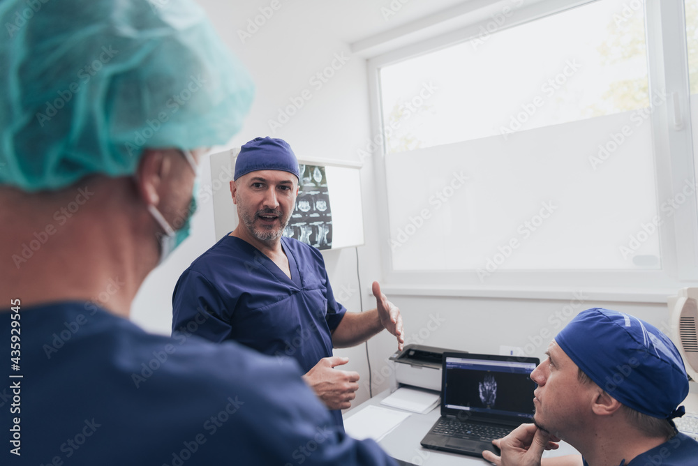 Orthopedist doctor team examining digital X-ray picture in clinic or hospital Orthopedist doctor team examining digital X-ray picture in clinic or hospital