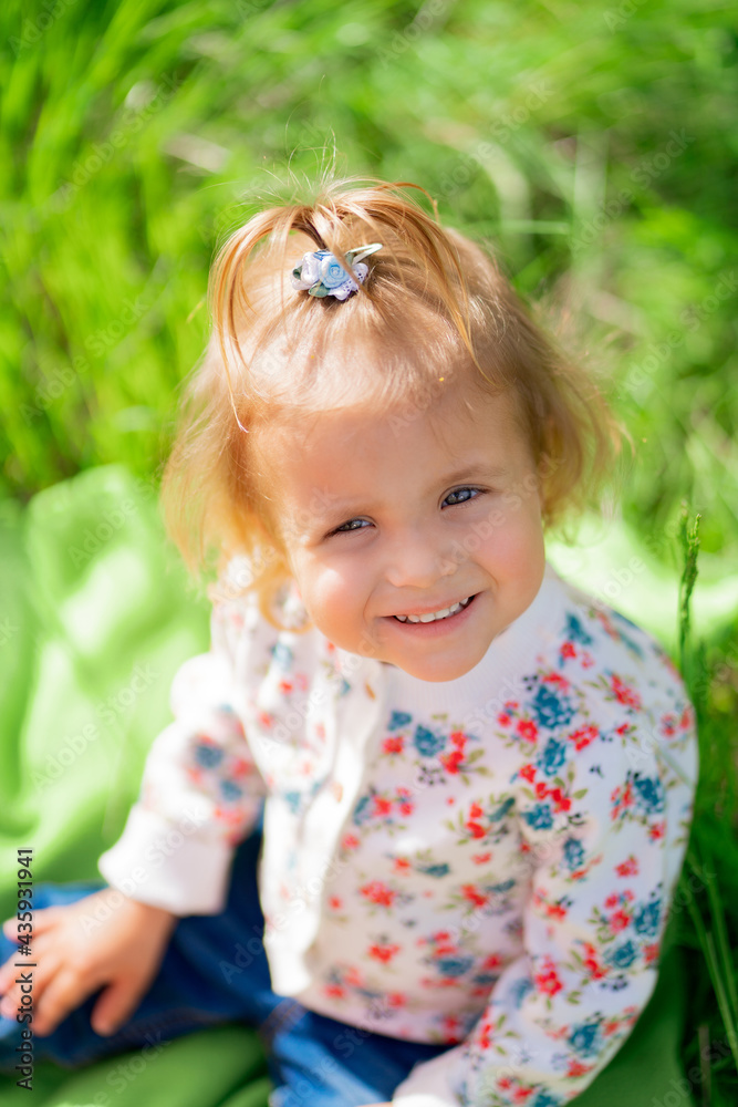 little cute girl on the green lawn in the park. little cute girl on the green lawn in the park.