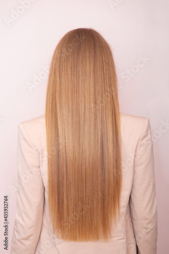Female back with long, straight, blonde hair, in hairdressing salon