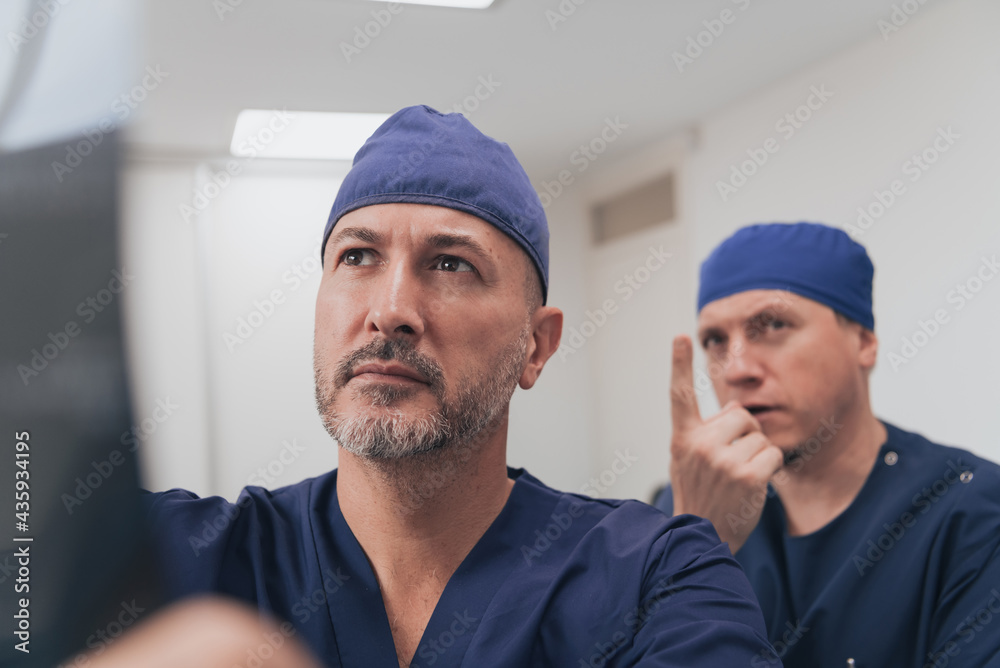 Orthopedist doctor team examining digital X-ray picture in clinic or hospital Orthopedist doctor team examining digital X-ray picture in clinic or hospital