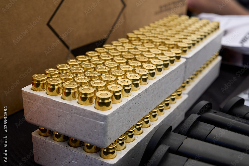 Boxes of brass casing 9mm pistol caliber ammo sitting on a table at the