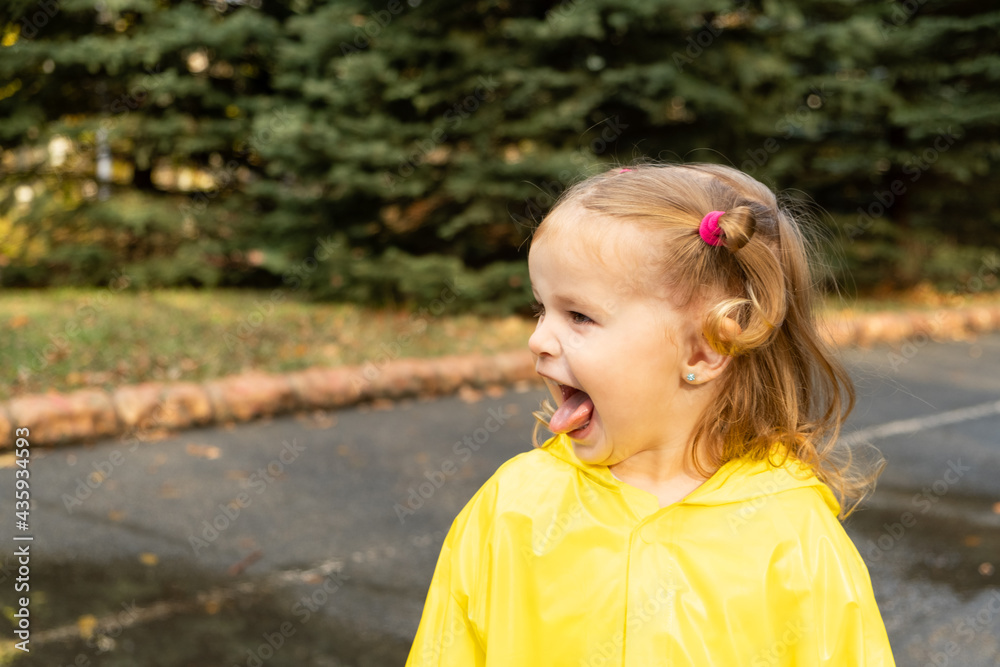 Cute blonde baby girl toddler wearing yellow stylish raincoat closeup. childhood. Cute blonde baby girl toddler wearing yellow stylish raincoat closeup. childhood.