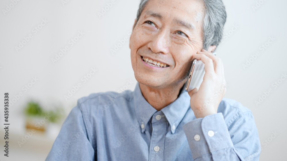 携帯電話で電話する高齢の男性　ポジティブ