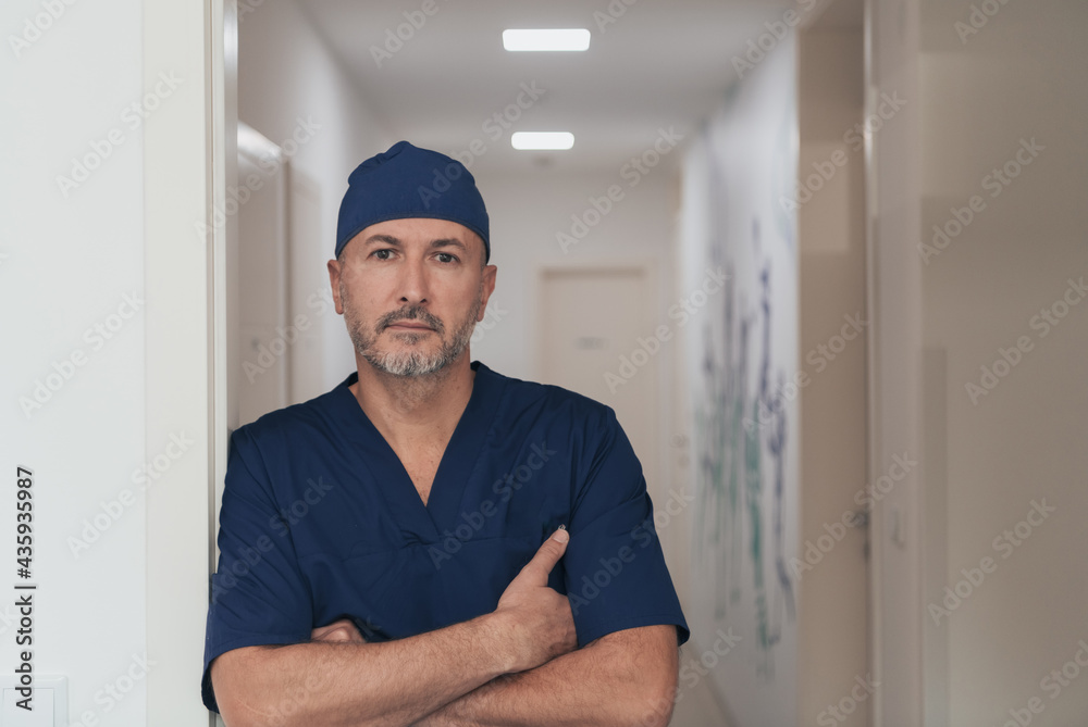 Portrait Of Mature Male Doctor In Busy Modern Hospital Corridor. Portrait Of Mature Male Doctor In Busy Modern Hospital Corridor.