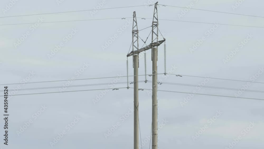Two of the electric post tower in the field with the long electric wires on it 
