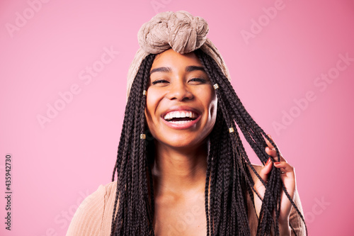 Happy Biracial Woman Posing In Front Of Pink Background photo