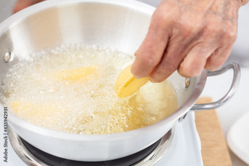 Senior woman frying a traditional dish from el Valle del Cauca in Colombia called empanada Senior woman frying a traditional dish from el Valle del Cauca in Colombia called empanada
