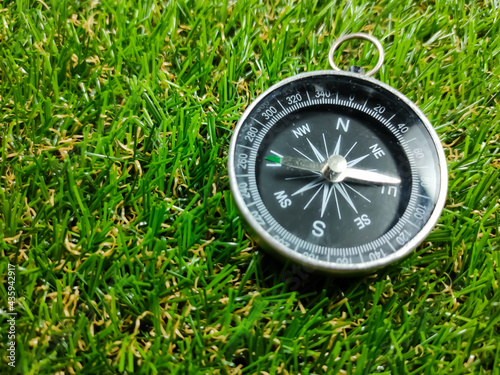 Compass on grass background. Travel concept.Compass with fresh green grass and copy space.