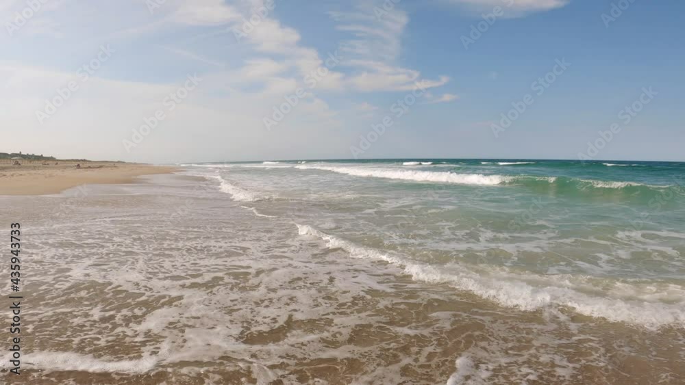 Beautiful sunny day on a calm pristine beach with blue skies in North Carolina in the Outer Banks in Nags Head during early summer Beautiful sunny day on a calm pristine beach with blue skies in North Carolina in the Outer Banks in Nags Head during early summer