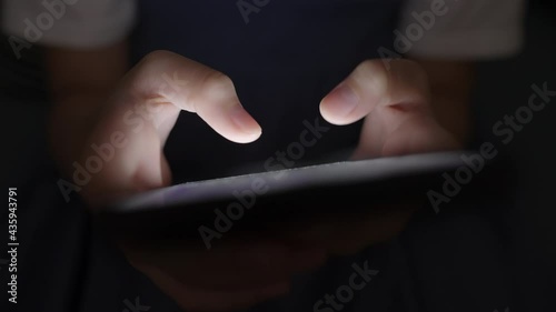 Hand of little girl using smartphone at night, typing message or chat