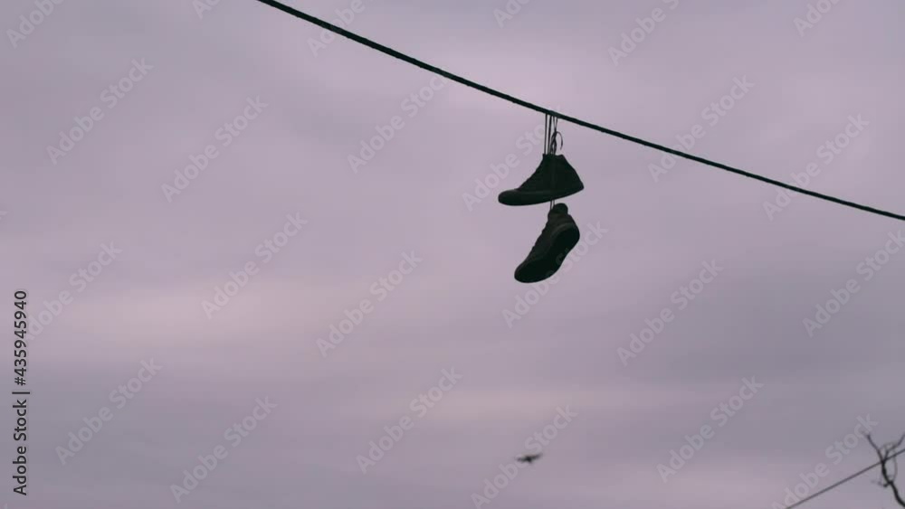 Old Shoes Hanging from power line by the laces. Old Shoes Hanging from power line by the laces.