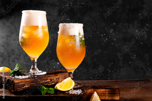 Obraz na plátně Two glasses of cold beer with lemon and mint, traditional latin american drink m