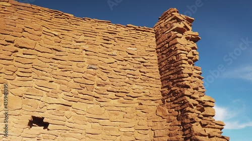 Ruins at Wukoki Pueblo on beautiful day with blue sky. Panning exterior shot. photo