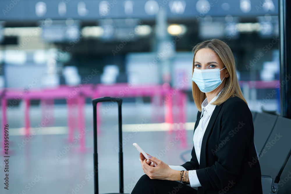 Adult female passenger using smartphone at the airport Adult female passenger using smartphone at the airport